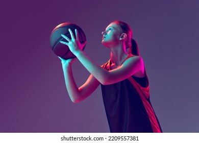 Portrait of sportive girl, basketball player training, preparing to throw a ball isolated over gradient pink purple background in neon. Concept of professional sport, health, active lifestyle - Powered by Shutterstock