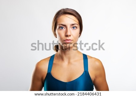 Similar – Close up front portrait of one young athletic woman in sportswear in gym over dark background, standing in boxing stance with hands and fists, looking at camera