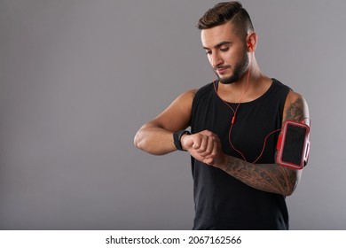 Portrait Of Sportsman Checking Heart Rate On Fitness Trekker After Training In Gym