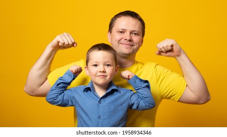 Portrait Of Sporty Dad And His Son On Color Background