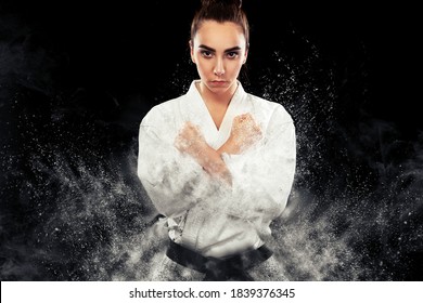 Portrait of sporty karate and taekwondo woman in white kimono with black belt on dark background. - Powered by Shutterstock