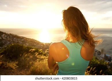 Portrait of sporty woman from behind watching the sunset