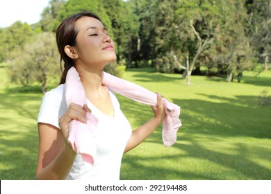 新鮮な空気を持つ公園で日差しの下でリラックスして幸せな気持ちのスポーティーな女性のポートレート