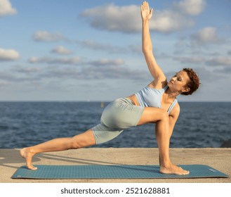 Portrait of sporty woman practicing various yoga poses on the seashore