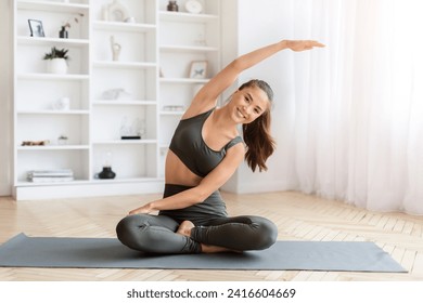 Portrait Of Sporty Young Asian Woman Making Stretching Exercises At Home, Happy Beautiful Korean Female In Activewear Training On Fitness Mat In Light Living Room, Enjoying Wellness, Copy Space - Powered by Shutterstock