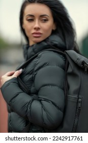 Portrait of a sporty young brunette woman outdoors in outerwear