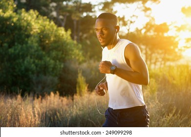 Portrait Of A Sporty Young Man Running Outdoors In Nature