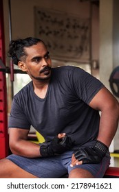 Portrait Sri Lanka Bodybuilder Man Looking Away At Old Gym. Sportsman Sitting And Deep Thinking. Athletic Asian Man Posing Muscle Workout. Sports And Bodybuilding Concept. Healthy Lifestyle