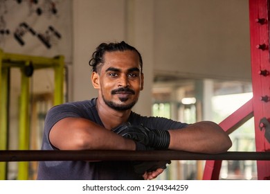 Portrait Sri Lanka Bodybuilder Man Looking At Camera At Old Gym. Sportsman Standing At Barbell. Athletic Asian Man Posing Muscles Workout. Sports And Bodybuilding Concept. Healthy Lifestyle