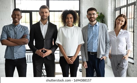 Portrait of standing in row smiling diverse team posing differently looking at camera. Happy young multiethnic corporate staff, bank workers photo shoot, HR agency recruitments.
