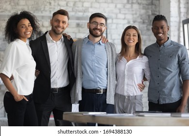 Portrait Of Standing In Row Smiling Multiracial Team Embracing Looking At Camera. Happy Diverse Corporate Staff, Hugging Specialists, Bank Workers Photo Shoot, HR Agency Recruitments.