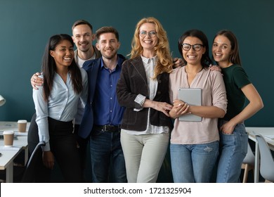 Portrait of standing in row smiling team embracing looking at camera. Happy diverse corporate staff, hugging specialists, company representatives, bank workers photo shoot, HR agency recruitments.