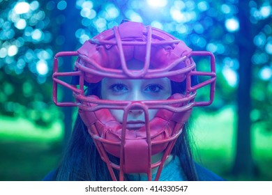 Portrait Of Staring Teenage Girl In Park Wearing Red Umpire Mask