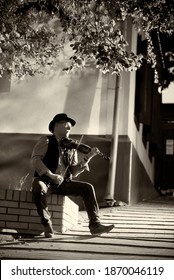 Portrait Of A Street Musician Man In A Hat With A Violin In The City.