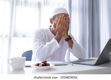 Portrait Of Stress Muslim Man Using Laptop Cover His Face With Hand During Working From Home