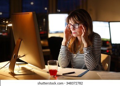 Portrait Of Stressed Businesswoman Sitting At Office Desk And Thinking The Solution While Working Late In Front Of A Computer.