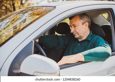 Portrait Of Stressed Mature Man In Car Drivers Seat. Crisis Of Middle Age And Man's Life After 50 Years. Senior Serious Or Sad Or Depressed Man Sitting In His Car, Toned