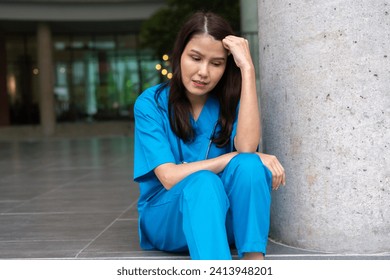 Portrait of stressed and overworked female doctor medical worker surgeon sitting on the floor near the operating room in the hospital and take off the mask - Powered by Shutterstock