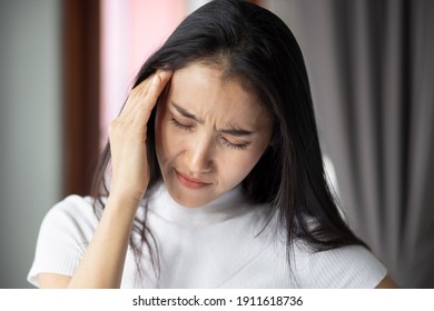 portrait of stressed sick asian woman with headache, depressed woman suffers from vertigo, dizziness, migraine, hangover, overwork, office syndrome depicting health care and mental health concept