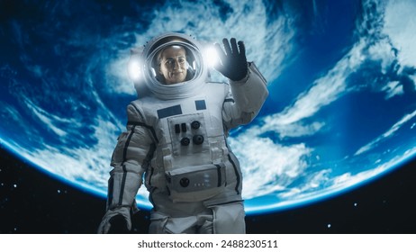 Portrait of Strong Female Astronaut Floating Outside a Spaceship with Planet Earth in the Background. Woman Waving to the Camera. Professional Spacewoman Posing in Space Suit, Smiling - Powered by Shutterstock