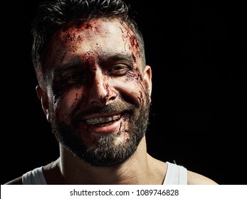 Portrait of a strong man with a beard, face in blood. He looks at the camera with different emotions. Blood and sweat dripping down his face. Fists erased from strikes