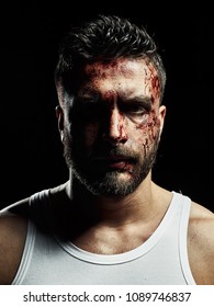 Portrait of a strong man with a beard, face in blood. He looks at the camera with different emotions. Blood and sweat dripping down his face. Fists erased from strikes