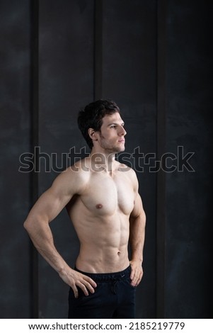 Portrait of strong man on dark background. Sport workout bodybuilding concept.