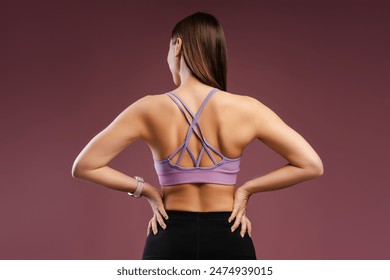 Portrait of strong sporty young woman wearing sport clothes posing in studio, back view. Training, sport, workout concept - Powered by Shutterstock