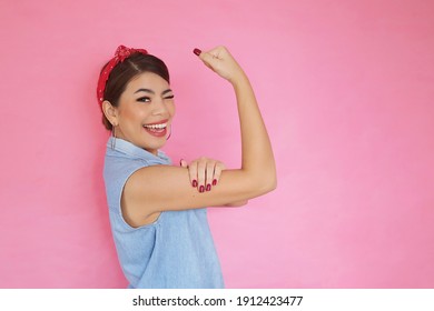 Portrait Strong Woman Showing Her Bicep Over Pink Background,We Can Do It Power Of Woman Concept.