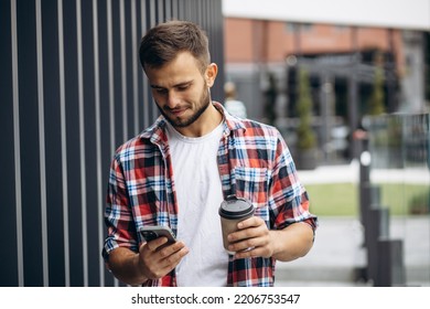 Portrait Of Student Boy Drinking Coffee And Using Phone