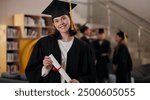 Portrait, student and happy girl at graduation with diploma in university for future success or achievement. Face, woman and college graduate with scroll for education milestone, award or certificate