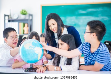 Portrait student looking at globe while listening to teacher with magnifying glass  - Powered by Shutterstock