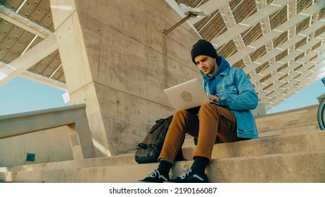 Portrait Of Student Work On Laptop Outside, Type Code Or Text For New Idea Project. Young Freelance Worker Work Remote From Office In Park Or Urban Area. Concentrated On Work. Commuter With Bicycle