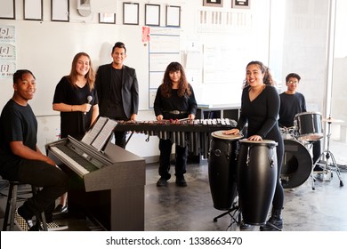 Portrait Of Students At Performing Arts School Playing In Band At Rehearsal With Teacher