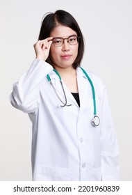 Portrait Studio Isolated Cutout Closeup Shot Of Asian Professional Successful Female Doctor In Lab Coat With Stethoscope Smiling Look At Camera Holding Hand Adjusting Eyeglasses On White Background.