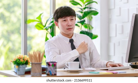 Portrait Studio Shot Of Asian Professional Successful Male Businessman Employee In Formal Shirt With Necktie Sitting Look At Camera At Working Desk With Computer Monitor Keyboard Mouse And Stationery.