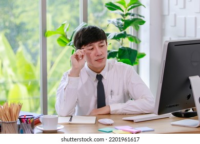 Portrait Studio Shot Of Asian Professional Successful Male Businessman Employee In Formal Shirt With Necktie Sitting Look At Camera At Working Desk With Computer Monitor Keyboard Mouse And Stationery.