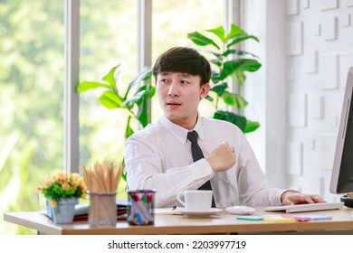 Portrait Studio Shot Of Asian Professional Successful Male Businessman Employee In Formal Shirt With Necktie Sitting Look At Camera At Working Desk With Computer Monitor Keyboard Mouse And Stationery.