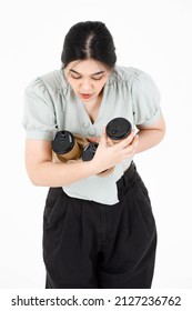 Portrait Studio Shot Of Asian Young Clumsy Teenager Female Model With Ponytail Hairstyle Wearing Casual Outfit Shocked And Surprised When Dropping Disposable Coffee Cups Holder On White Background.