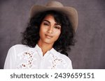 Portrait, studio and woman with cowgirl fashion, confidence and relax with girl in stetson hat. Rodeo, western style and face Mexican model with cowboy culture, wild west clothes and grey background