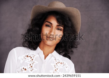 Portrait, studio and woman with cowgirl fashion, confidence and relax with girl in stetson hat. Rodeo, western style and face Mexican model with cowboy culture, wild west clothes and grey background