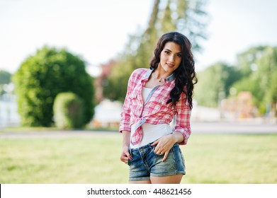 Portrait of style country girl on short jeans shorts and crosscountry checkered line shirt