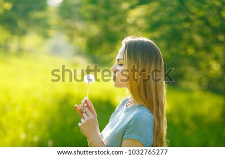 Portrait of a stylish and calm young beautiful woman with flowing blond hair looking at a dandelion against a background of blurry foliage on a walk in a spring park. European woman
LIFESTYLE
