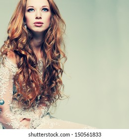 A portrait of stylish elegant redheaded girl is in lace clothes