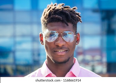 portrait stylish and handsome African student American man with cool dreadlocks and earringin the ear diamond fashion look walking on the street