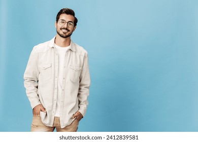 Portrait of a stylish man smile with teeth in glasses for farsightedness and myopia, on a blue background in a white T-shirt, fashionable clothing style, space space - Powered by Shutterstock