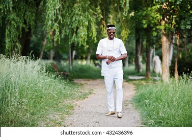 Portrait of stylish and rich black african american man on white clothes, sunglasses and hat 