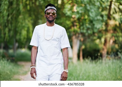 Portrait of stylish and rich black african american man on white clothes, sunglasses and hat 
