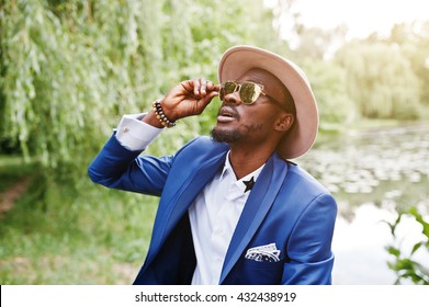 Portrait Of Stylish Rich Black Man At Blue Jacket, Hat And Sunglasses