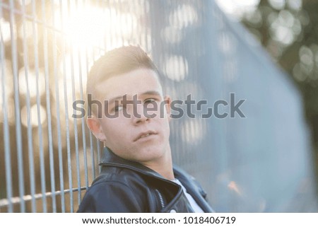 Similar – Stylish teenager sitting on a wooden bench on a city park